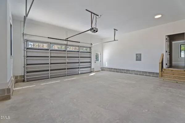 a view of a white house with a small yard and large tree