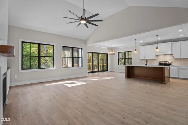 a view of an empty room with window and wooden floor