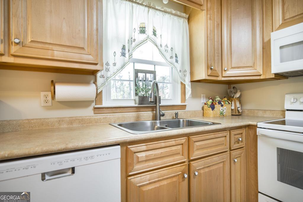 2574 Lower Hartley Bridge Road Byron, GA 31008 - Photo 12 of 45 a kitchen with stainless steel appliances white cabinets and a window