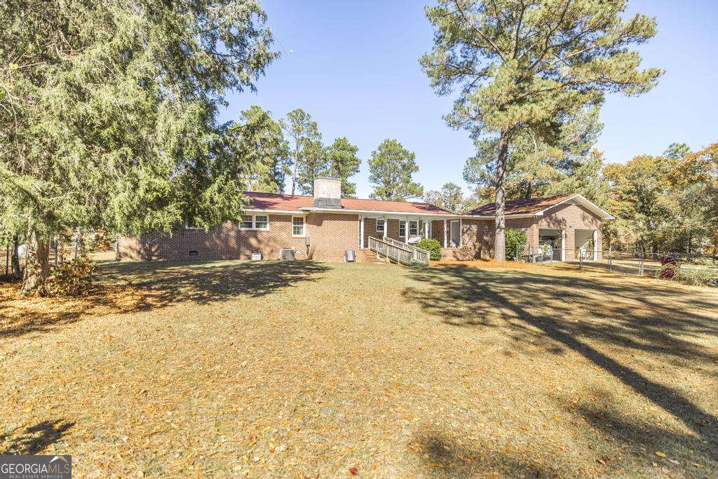 2574 Lower Hartley Bridge Road Byron, GA 31008 - Photo 29 of 45 a house with trees in front of it