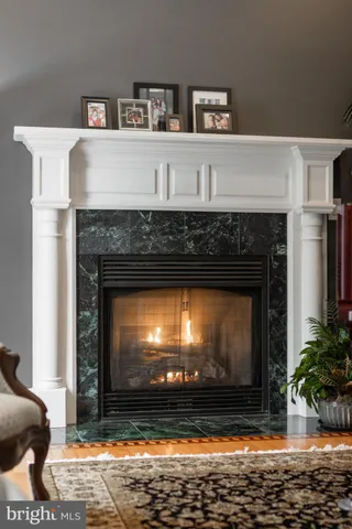 a kitchen with stainless steel appliances kitchen island granite countertop a refrigerator a stove and a wooden floors