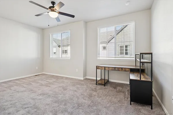 an empty room with windows and fan