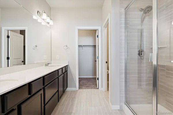 a bathroom with a double vanity sink a mirror and a shower