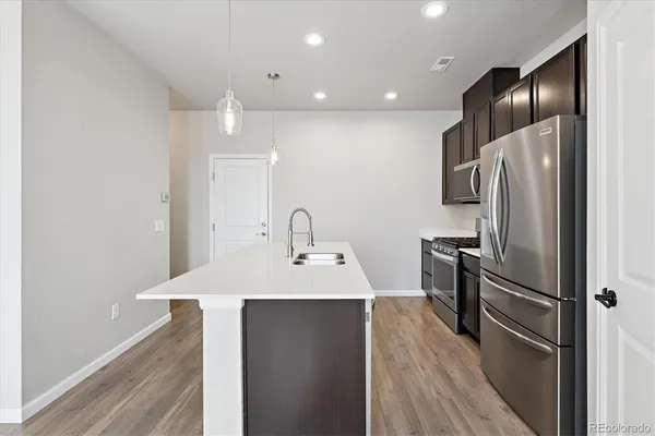 a kitchen with refrigerator cabinets and wooden floor