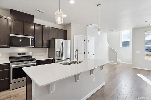 a kitchen with stainless steel appliances a stove refrigerator sink and microwave