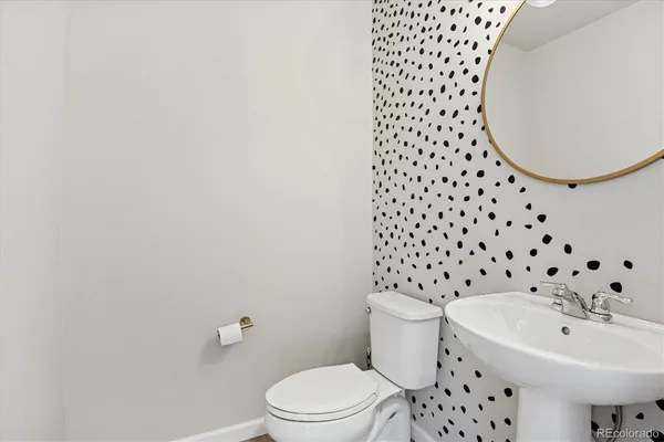 a bathroom with a sink toilet and a mirror