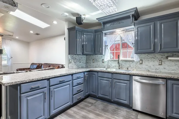 a kitchen with kitchen island granite countertop a sink stainless steel appliances and cabinets