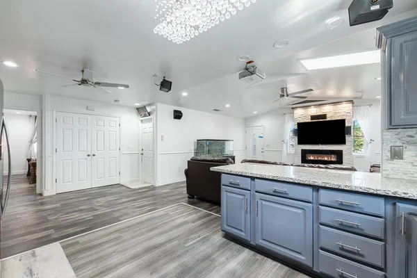 a large kitchen with a large counter space a sink stainless steel appliances and cabinets