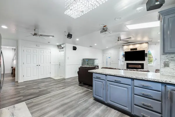 a large kitchen with a large counter space a sink stainless steel appliances and cabinets