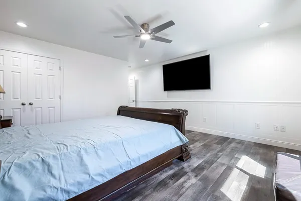 a bedroom with a bed window and a flat screen tv