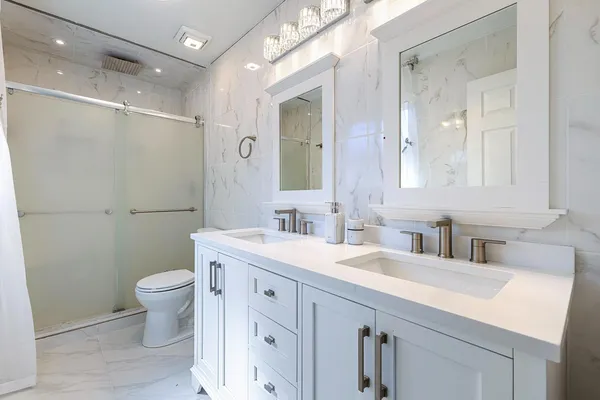 a bathroom with a sink a toilet a large mirror and shower