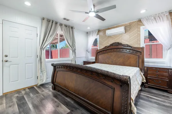 a bedroom with a bed next to a window and a chandelier