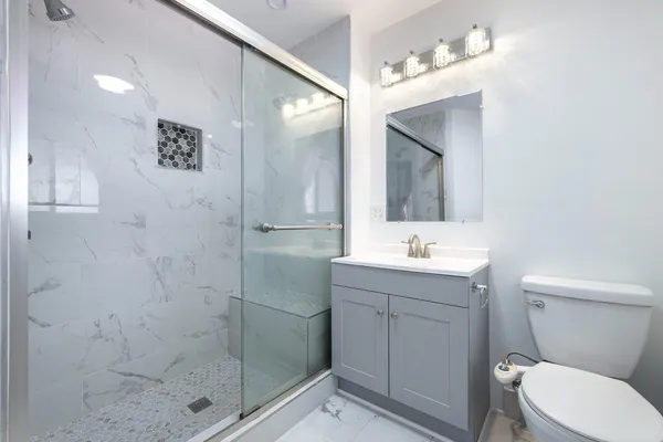 a bathroom with a sink a toilet and shower