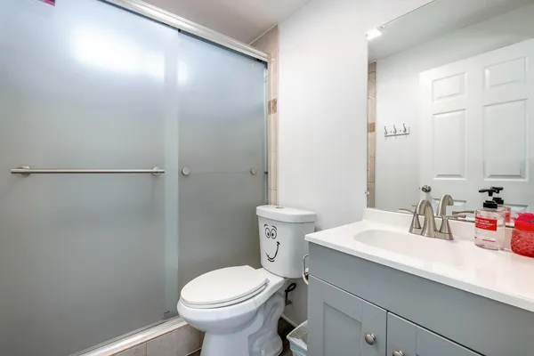 a bathroom with a sink a toilet and shower