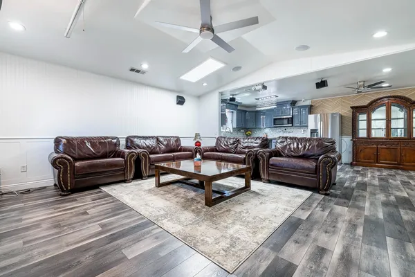 a living room with furniture and a wooden floor
