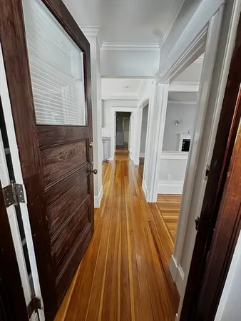a view of a hallway with wooden floor