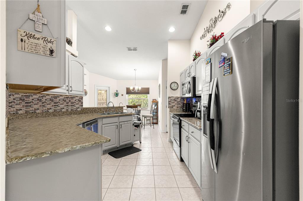 8601 Southwest 60th Circle Ocala, FL 34476 - Photo 11 of 45 a kitchen with stainless steel appliances granite countertop a refrigerator a stove and a sink
