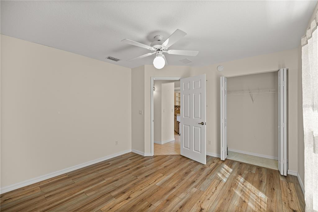8601 Southwest 60th Circle Ocala, FL 34476 - Photo 11 of 37 an empty room with wooden floor fan and windows