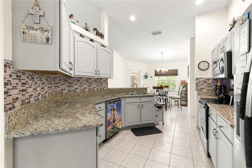8601 Southwest 60th Circle Ocala, FL 34476 - Photo 12 of 45 a kitchen with stainless steel appliances granite countertop a sink and cabinets