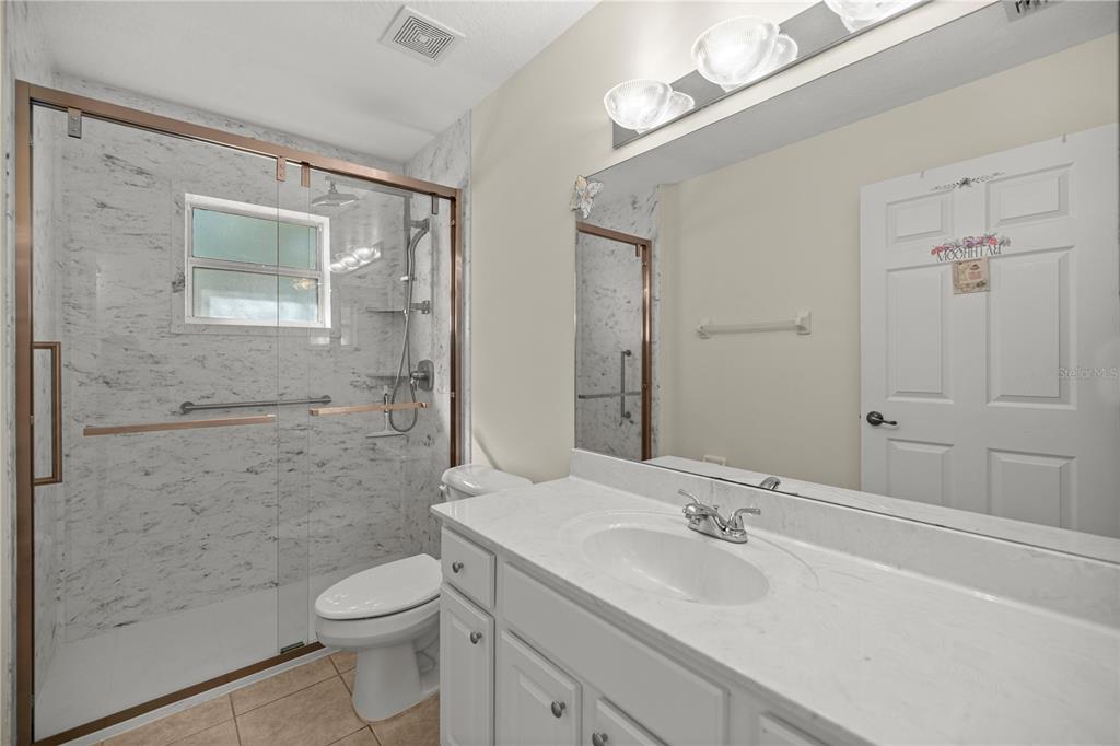 8601 Southwest 60th Circle Ocala, FL 34476 - Photo 12 of 37 a bathroom with a sink a toilet and shower