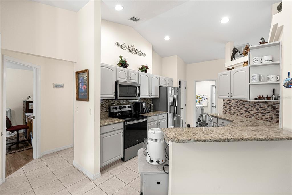 8601 Southwest 60th Circle Ocala, FL 34476 - Photo 13 of 45 a kitchen with stainless steel appliances granite countertop a sink stove and refrigerator