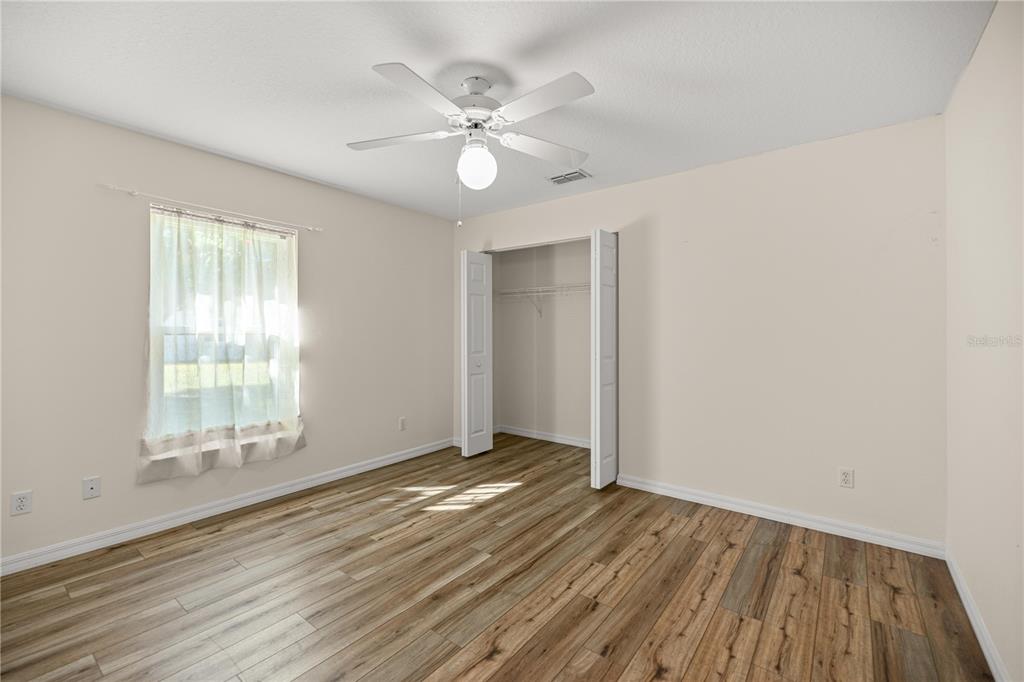 8601 Southwest 60th Circle Ocala, FL 34476 - Photo 13 of 37 an empty room with wooden floor fan and windows