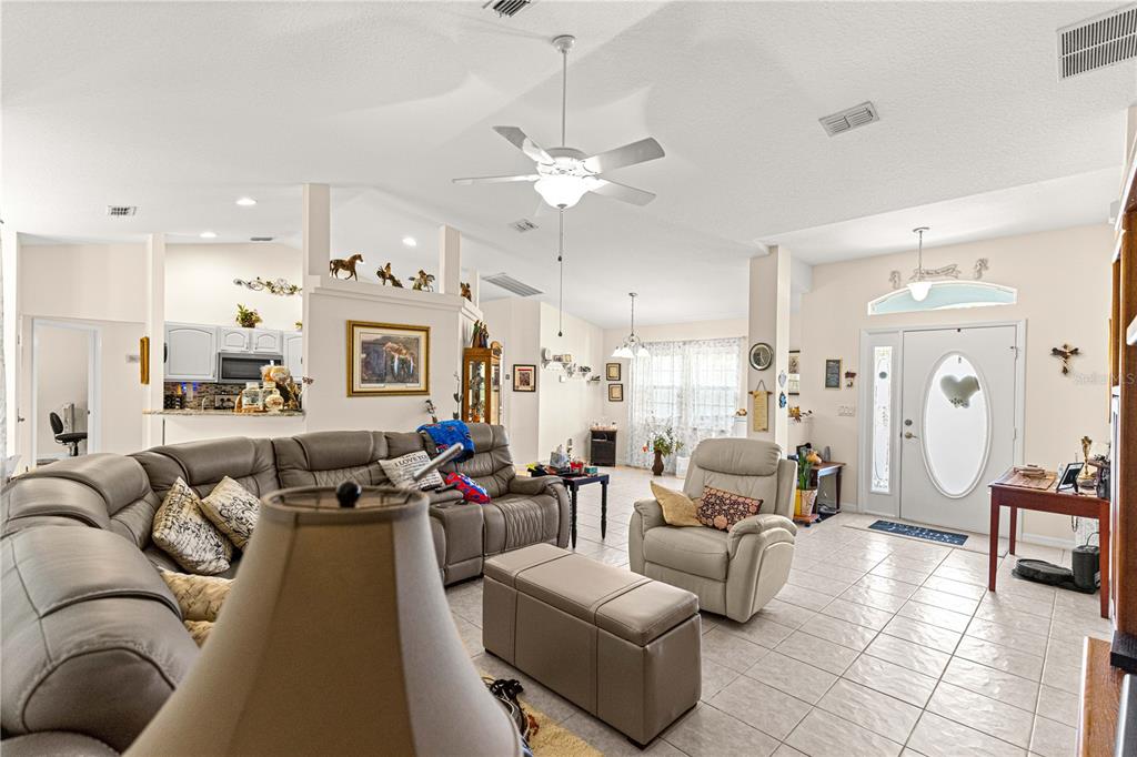 8601 Southwest 60th Circle Ocala, FL 34476 - Photo 4 of 45 a living room with furniture kitchen view and a chandelier
