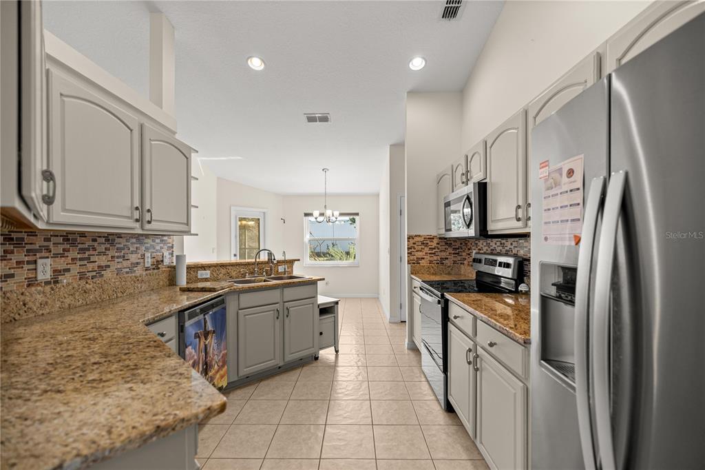 8601 Southwest 60th Circle Ocala, FL 34476 - Photo 7 of 37 a kitchen with stainless steel appliances granite countertop a stove top oven a refrigerator a sink and dishwasher