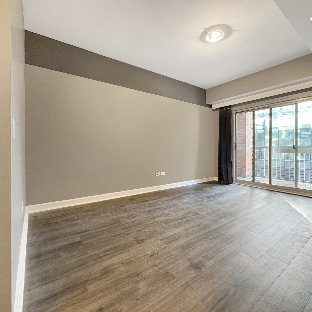 720 West Randolph Street, Unit 608 Chicago, IL 60661 - Photo 25 of 40 a view of an empty room with wooden floor and a window