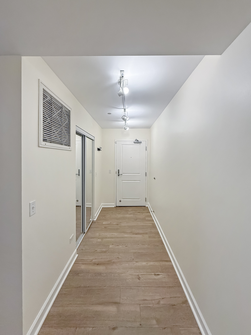 720 West Randolph Street, Unit 608 Chicago, IL 60661 - Photo 3 of 40 a view of a hallway with wooden floor and a ceiling fan
