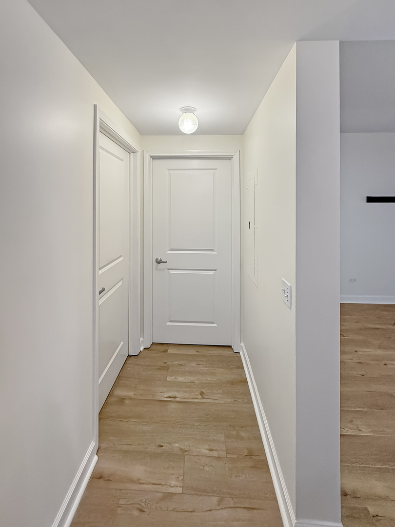 720 West Randolph Street, Unit 608 Chicago, IL 60661 - Photo 5 of 40 a view of hallway with an empty room and wooden floor