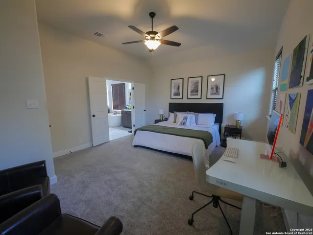 a spacious bedroom with a bed and a flat screen tv