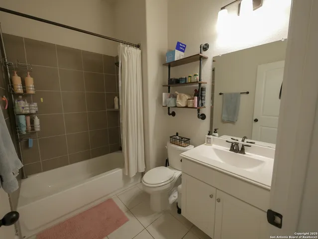 a bedroom with bed and a painting on the wall