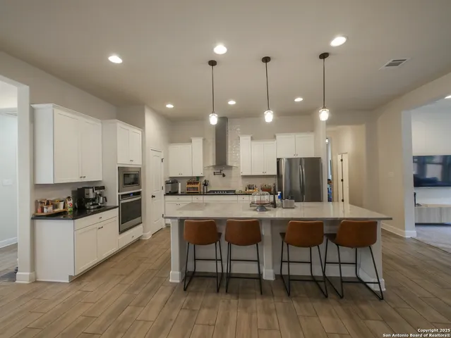 a large kitchen with stainless steel appliances kitchen island granite countertop a large counter top and stainless steel appliances