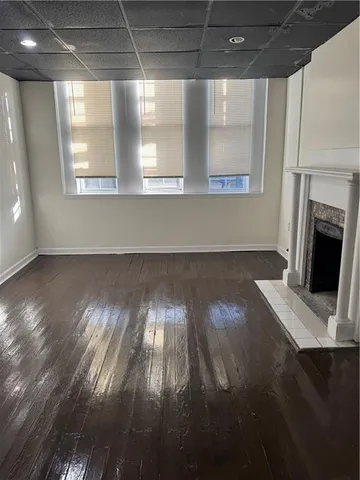 a view of a livingroom with wooden floor and a fireplace