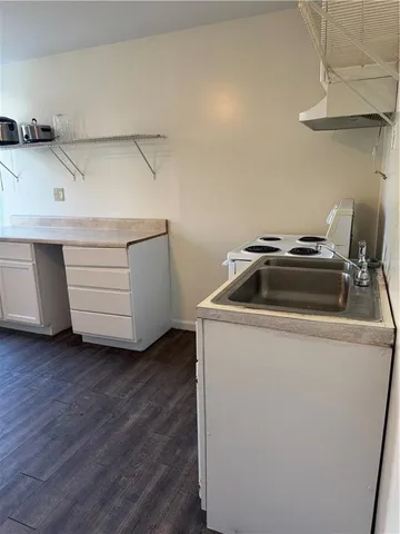 a kitchen with a refrigerator and white cabinets