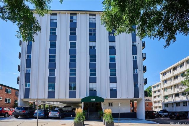 a living room with furniture a flat screen tv and gym equipment