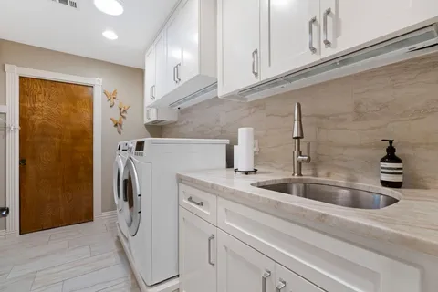 a kitchen with stainless steel appliances granite countertop a sink and a refrigerator