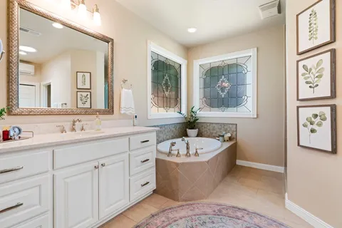 a bathroom with a large tub sink and mirror