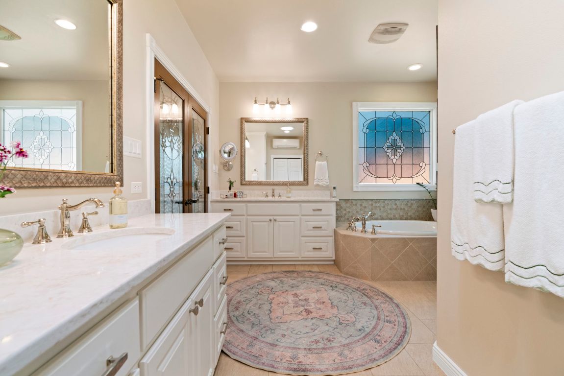 2911 Gabriel View Drive Georgetown, TX 78628 - Photo 24 of 39 a bathroom with a granite countertop sink mirror and a bath tub