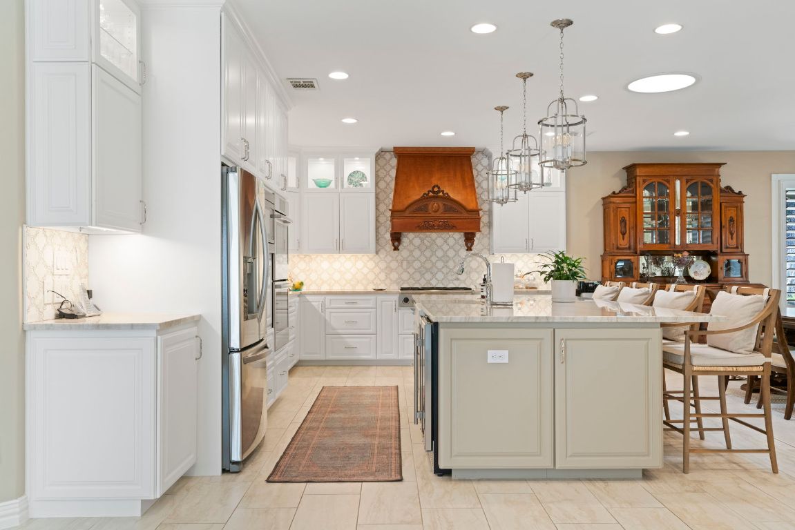 2911 Gabriel View Drive Georgetown, TX 78628 - Photo 7 of 39 a kitchen with kitchen island granite countertop a sink and refrigerator