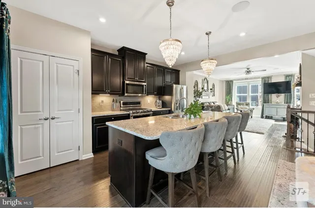 a kitchen with stainless steel appliances granite countertop a stove refrigerator and microwave