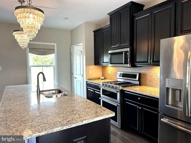 a kitchen with stainless steel appliances granite countertop a stove and a sink