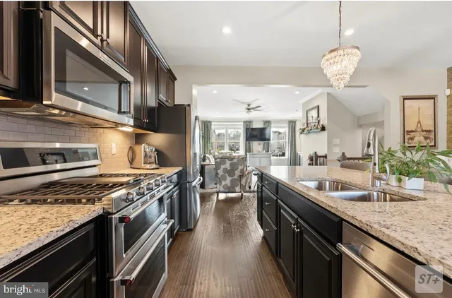 a kitchen with stainless steel appliances granite countertop a sink refrigerator and microwave