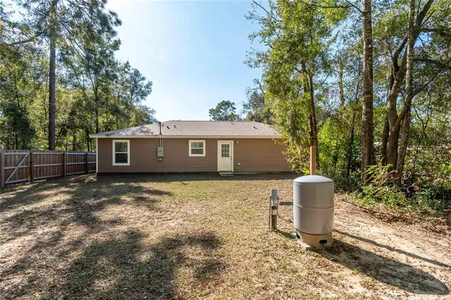 a view of backyard with wooden fence and trees
