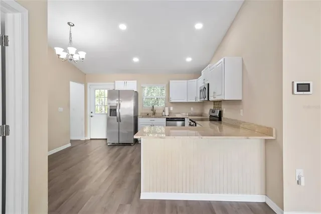 a kitchen with white cabinets stainless steel appliances and a sink