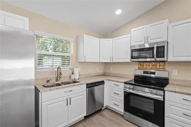 a view of kitchen with stainless steel appliances refrigerator oven and stove