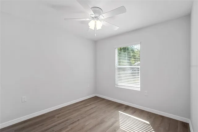 an empty room with wooden floor and closet area