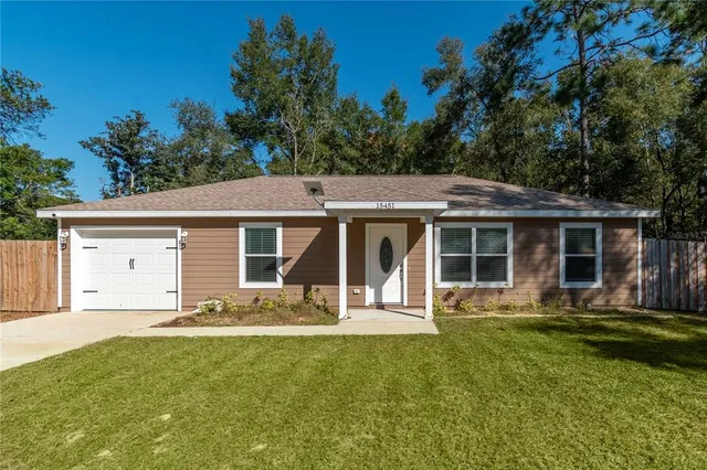 a front view of house with a garden and trees