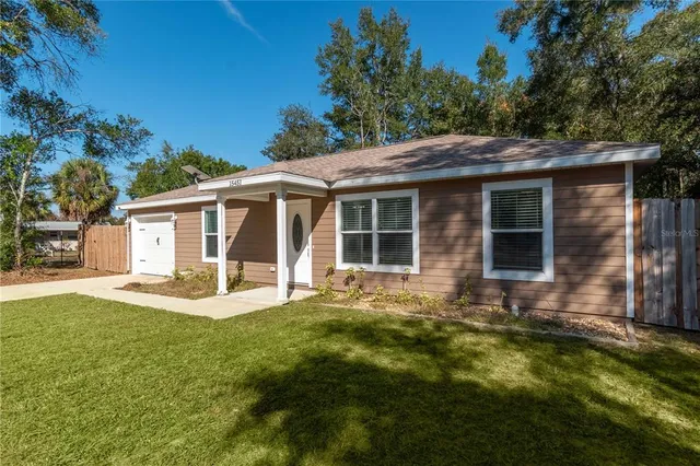 a view of a house with a yard and sitting area